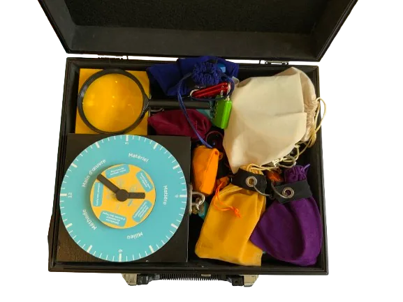 Matériel physique du projet AIA — valise ouverte avec disque d'instructions et sachets colorés